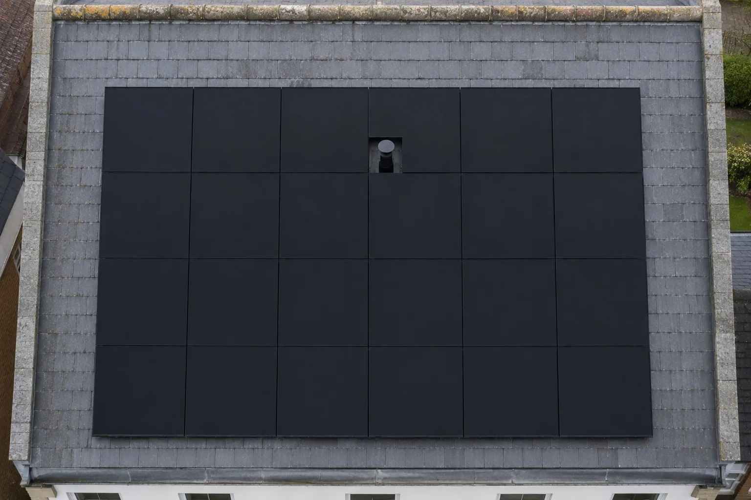 All-black Canadian Solar roof Straight-down aerial of a roof slope with a black solar array shaped neatly around a vent pipe