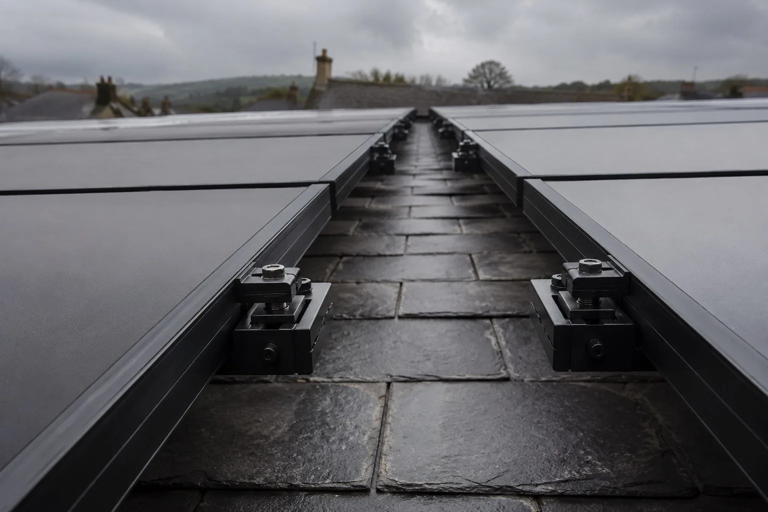 Power your UK home with Canadian Solar Looking along the gap between two rows of solar modules on a roof, rails and clamps receding